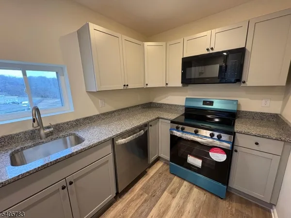 a kitchen with stainless steel appliances granite countertop a sink and a stove top oven