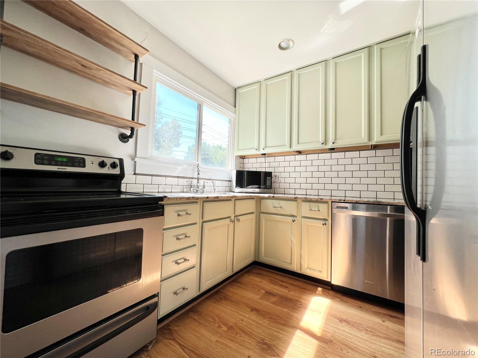 1146 Jackson Street Denver, CO 80206 - Photo 2 of 11 a kitchen with stainless steel appliances a stove sink and microwave