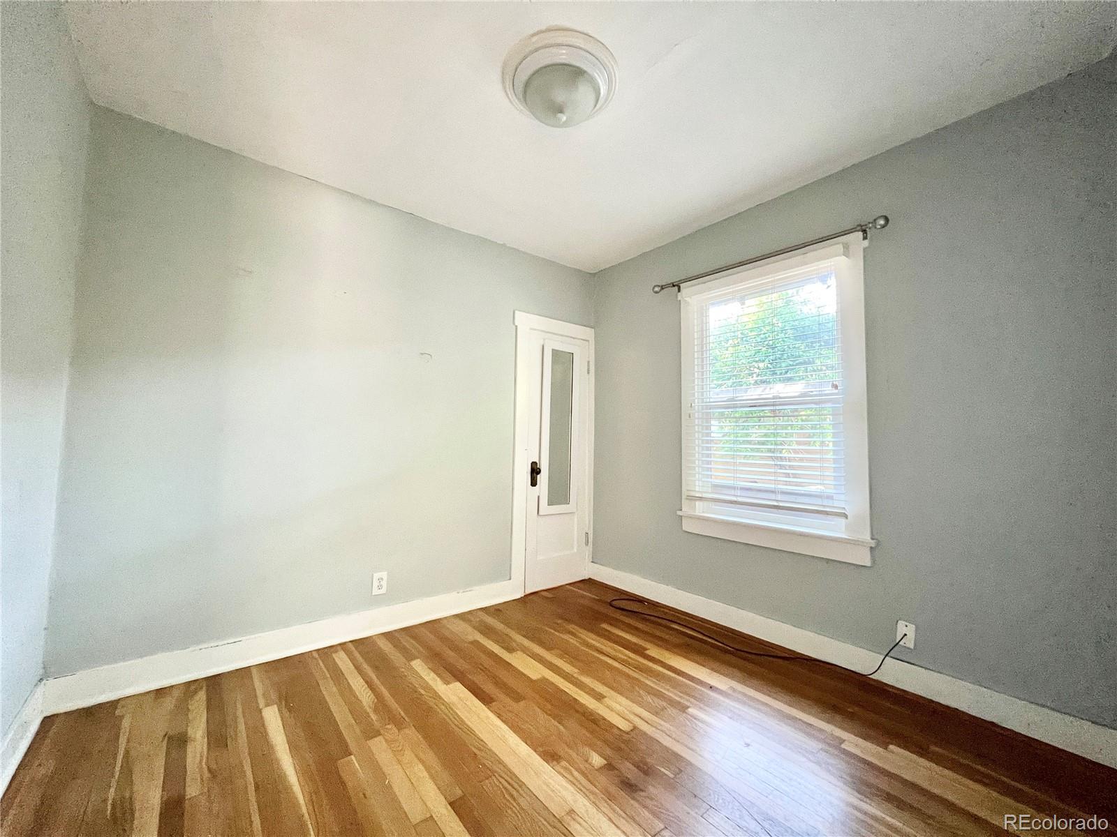 1146 Jackson Street Denver, CO 80206 - Photo 6 of 11 a view of a room with wooden floor and windows