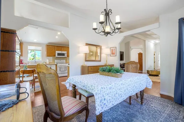 a view of a dining room with furniture a chandelier and wooden floor