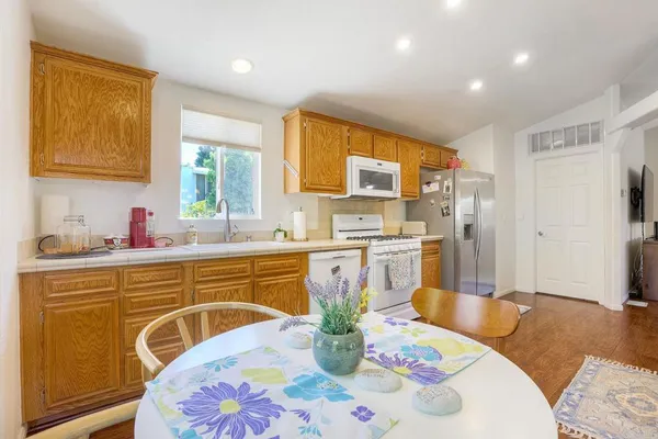 a kitchen with stainless steel appliances granite countertop a sink a microwave a dining table and chairs