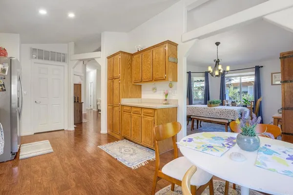 a large kitchen with sink refrigerator dining table and chairs