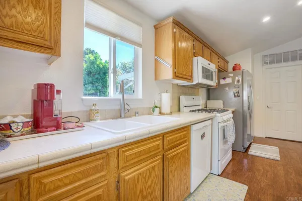 a kitchen with stainless steel appliances sink cabinets and window