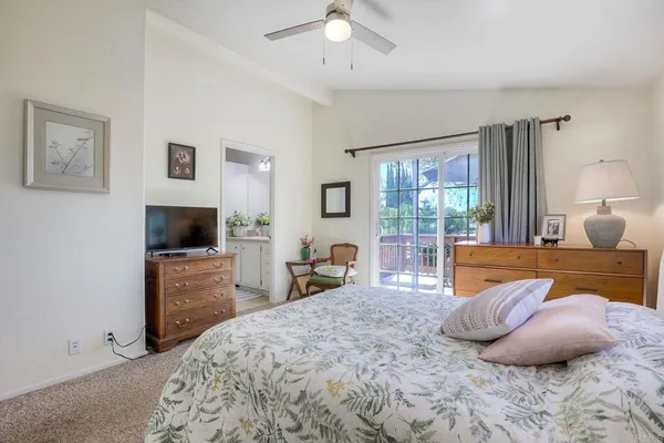 a bedroom with a large bed and a flat tv screen