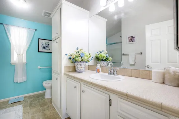 a bathroom with a granite countertop sink and a mirror