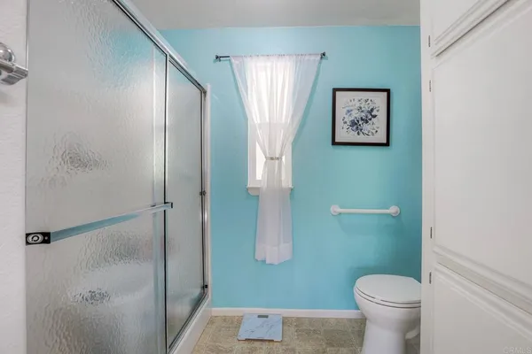 a bathroom with a toilet and a shower