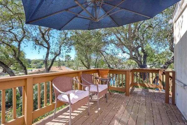a view of deck with furniture and umbrella
