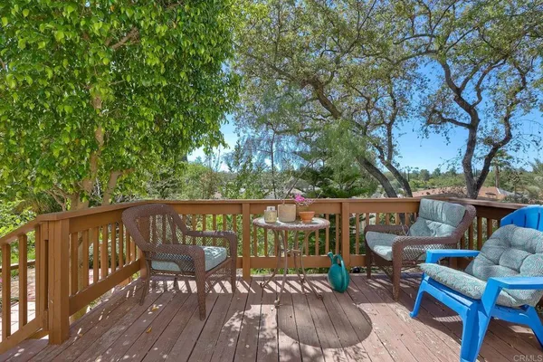 a balcony with wooden floor table and chairs