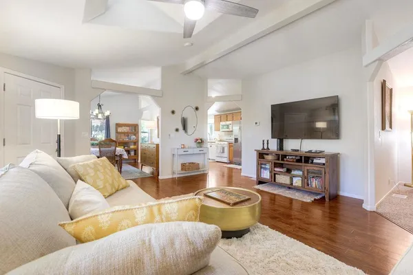 a living room with furniture flat screen tv and wooden floor