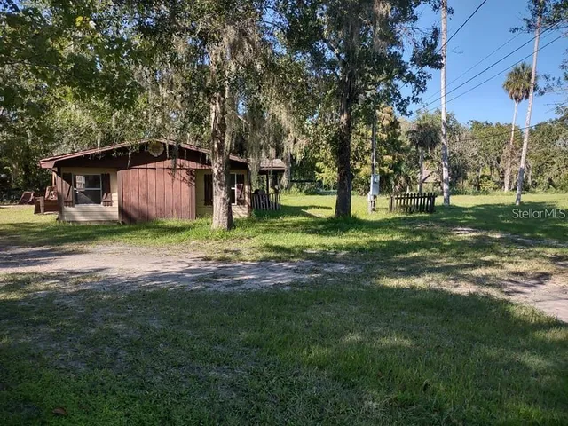 a front view of a house with a yard and trees