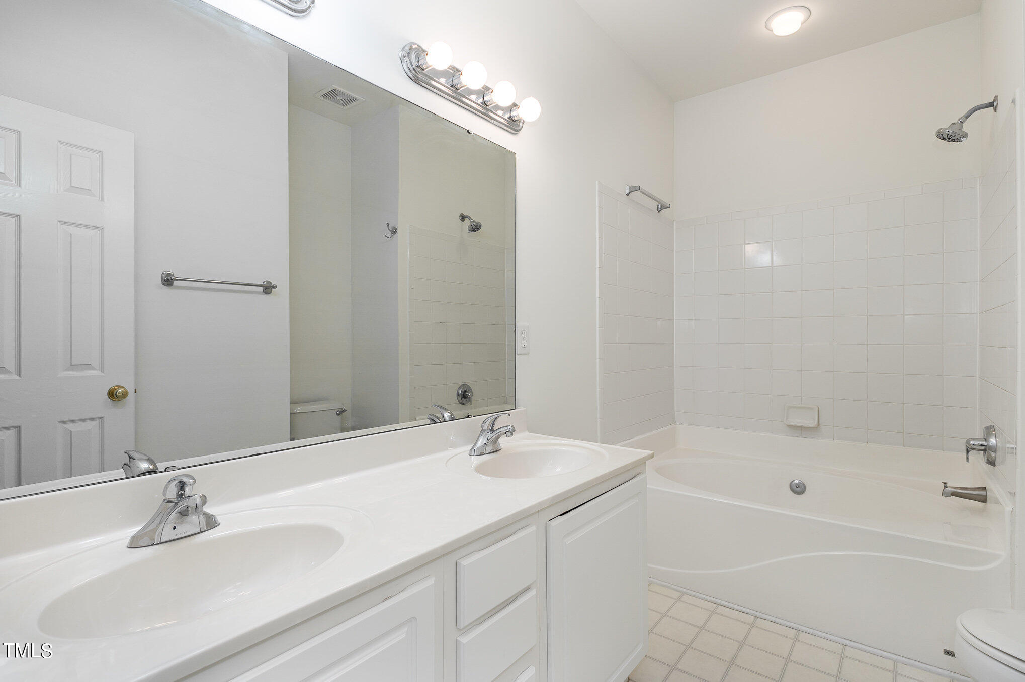5604 Slide Rock Lane Raleigh, NC 27613 - Photo 18 of 23 1st floor Primary Bath with dual vanities- bright and white.