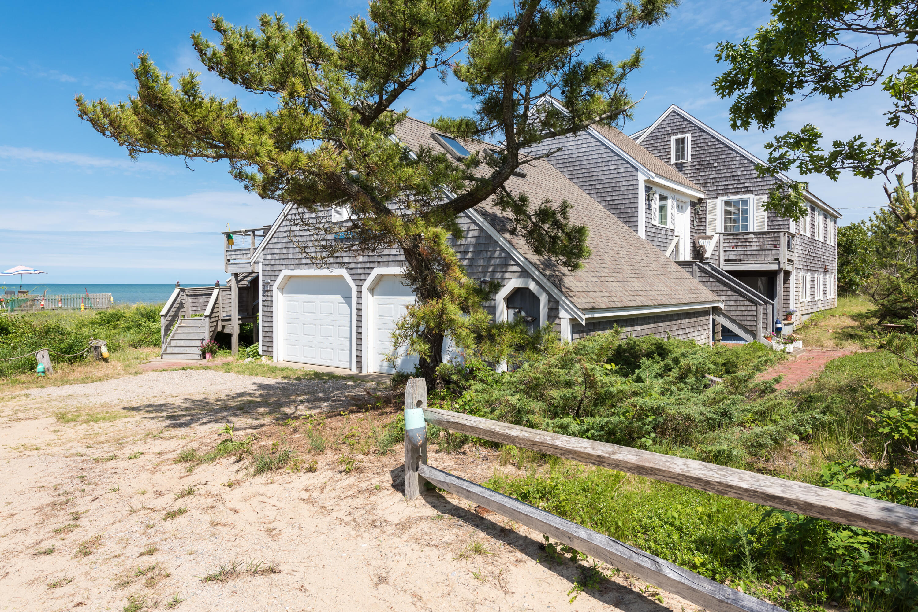 85 Sparrow Road Eastham, MA 02642 - Photo 2 of 43 a front view of a house with a yard and potted plants