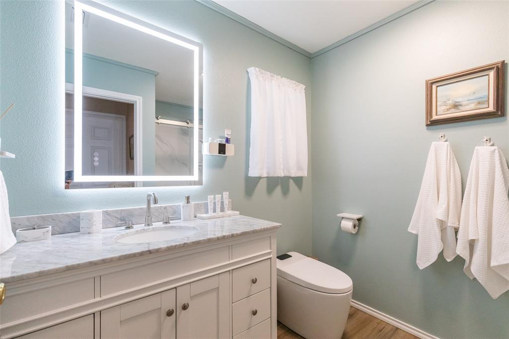 1603 Derrick Drive Haskell, TX 79521 - Photo 19 of 37 a bathroom with a granite countertop toilet sink and a mirror