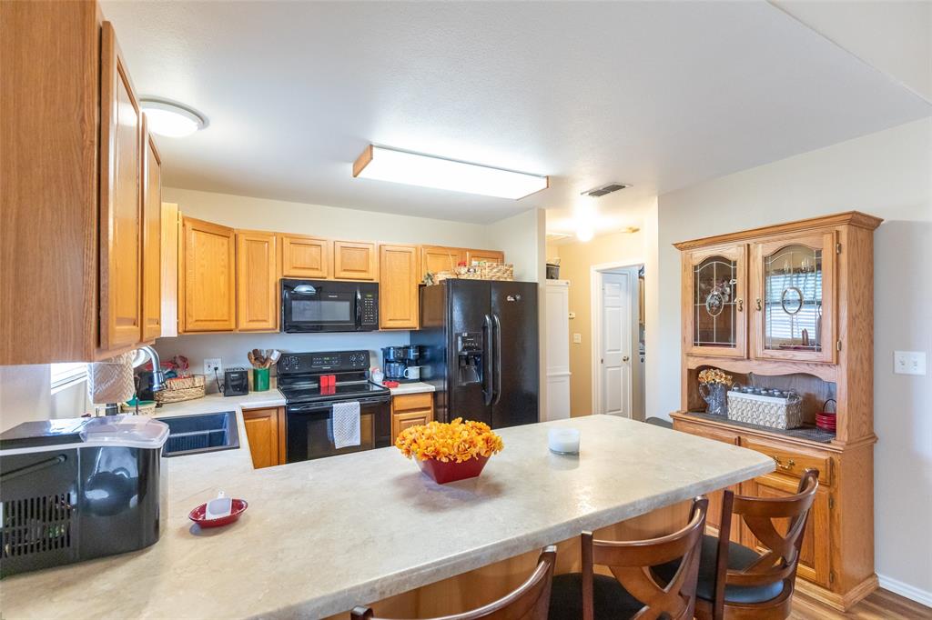 1603 Derrick Drive Haskell, TX 79521 - Photo 8 of 37 a kitchen with stainless steel appliances a sink a stove a refrigerator a dining table and chairs