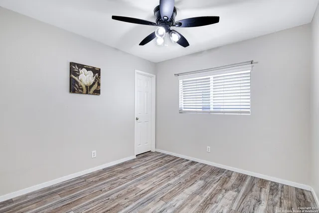 a view of empty room with wooden floor