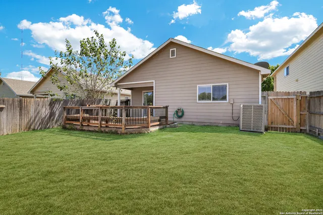 a view of a house with a yard and deck