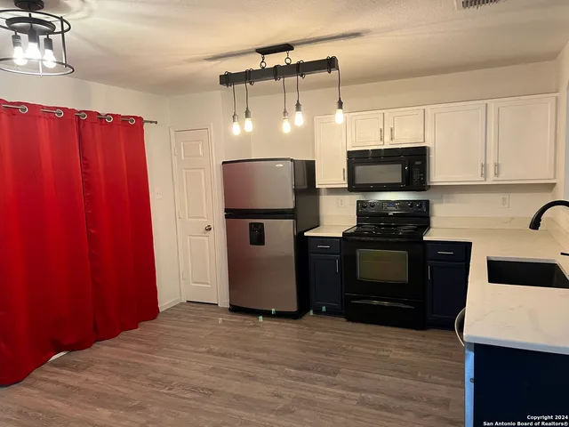 a kitchen with a refrigerator and a stove top oven