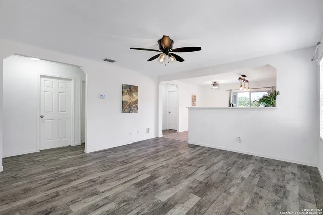 a view of a kitchen with wooden floor and a ceiling fan