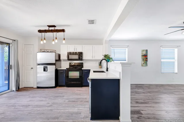 a kitchen with stainless steel appliances a stove top oven a sink dishwasher and a refrigerator