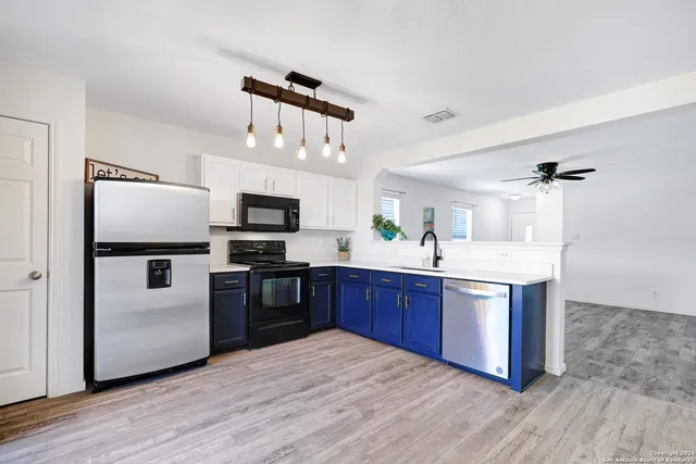 a kitchen with stainless steel appliances kitchen island granite countertop a refrigerator a stove top oven and sink