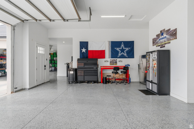 2278 Tawny Ridge Circle St. George, UT 84790 - Photo 46 of 61 Spacious garage featuring a durable epoxy floor, white walls, overhead garage door, and a white interior door with windows.