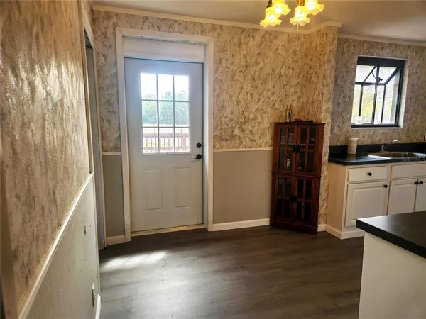 a view of a kitchen with an entryway and a wooden floor