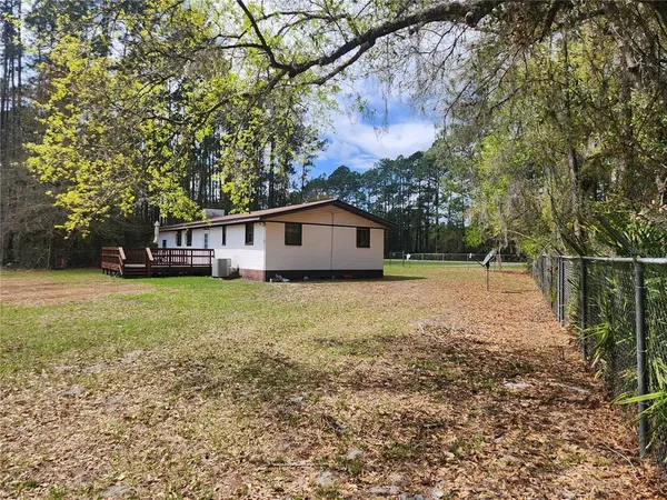 a view of a pool with a yard and large trees