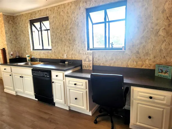 a kitchen with granite countertop a sink cabinets and window