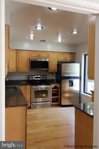 a kitchen with stainless steel appliances granite countertop a stove and a microwave
