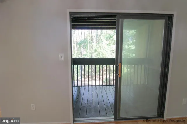 a view of a hallway with wooden floor and a chandelier
