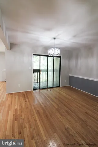 a view of empty room with wooden floor and fireplace