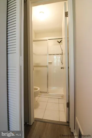 a view of empty room with wooden floor and ceiling fan