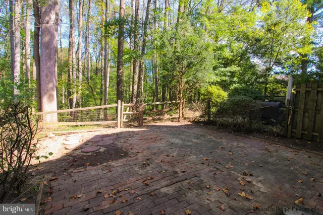 a view of backyard with green space and wooden fence