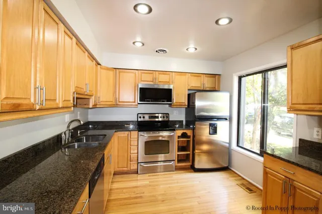 a kitchen with stainless steel appliances a stove a refrigerator and a microwave