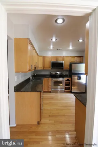a kitchen with granite countertop cabinets stainless steel appliances and a sink