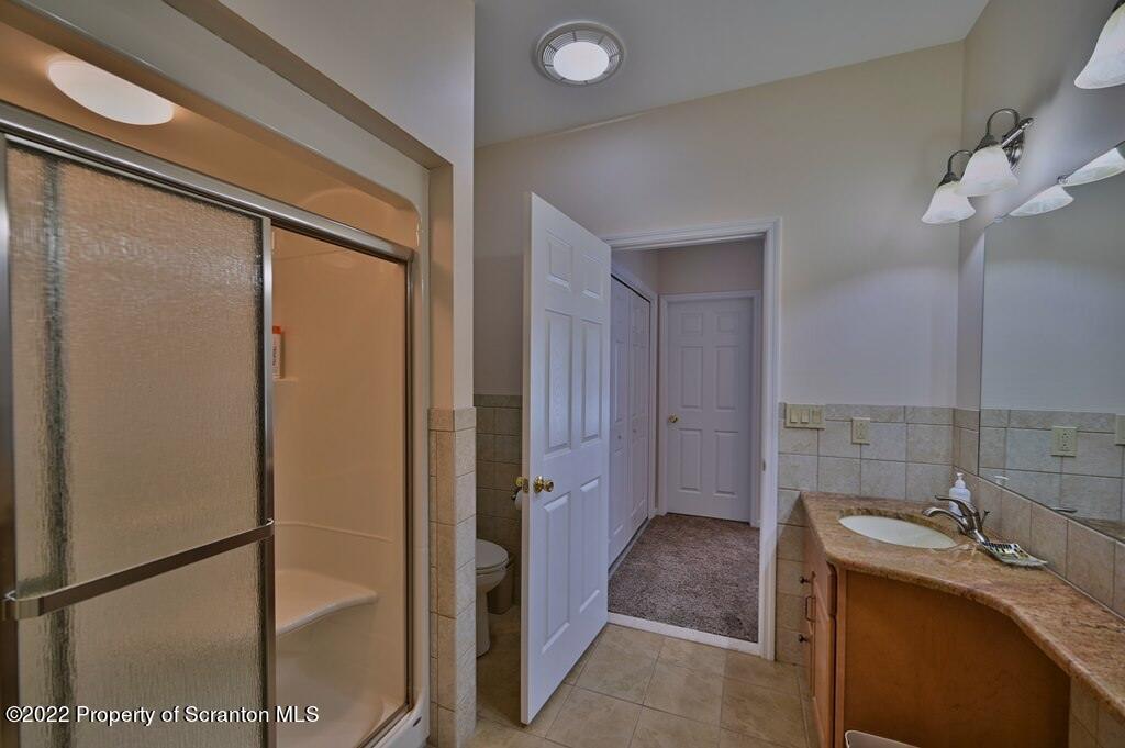 133 Pierce Street Eynon, PA 18403 - Photo 32 of 55 a bathroom with a granite countertop sink a mirror and shower