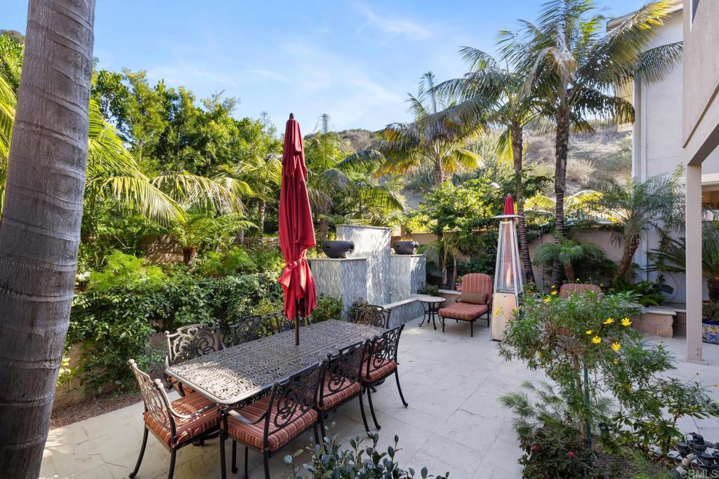 2721 MacKinnon Ranch Road Cardiff-by-the-Sea, CA 92007 - Photo 31 of 38 a backyard of a house with table and chairs plants