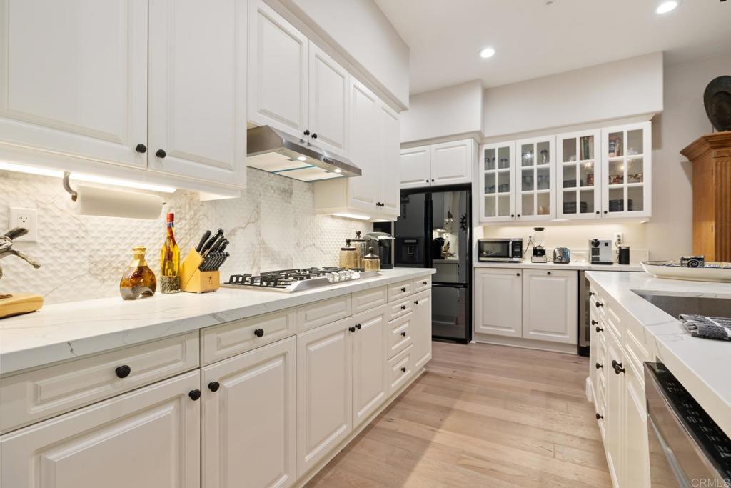 2721 MacKinnon Ranch Road Cardiff-by-the-Sea, CA 92007 - Photo 4 of 38 a kitchen with granite countertop white cabinets and white appliances