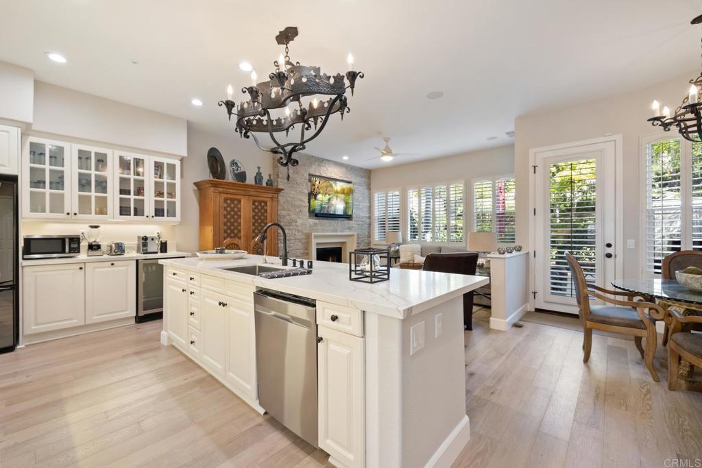 2721 MacKinnon Ranch Road Cardiff-by-the-Sea, CA 92007 - Photo 7 of 38 a kitchen that has a lot of cabinets a sink a stove and wooden floor