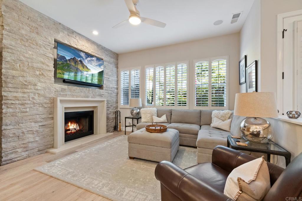 2721 MacKinnon Ranch Road Cardiff-by-the-Sea, CA 92007 - Photo 9 of 38 a living room with furniture a flat screen tv and a fireplace