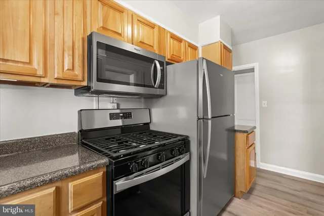 a kitchen with stainless steel appliances granite countertop a stove microwave and refrigerator