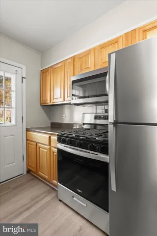 a kitchen with granite countertop stainless steel appliances and wooden cabinets