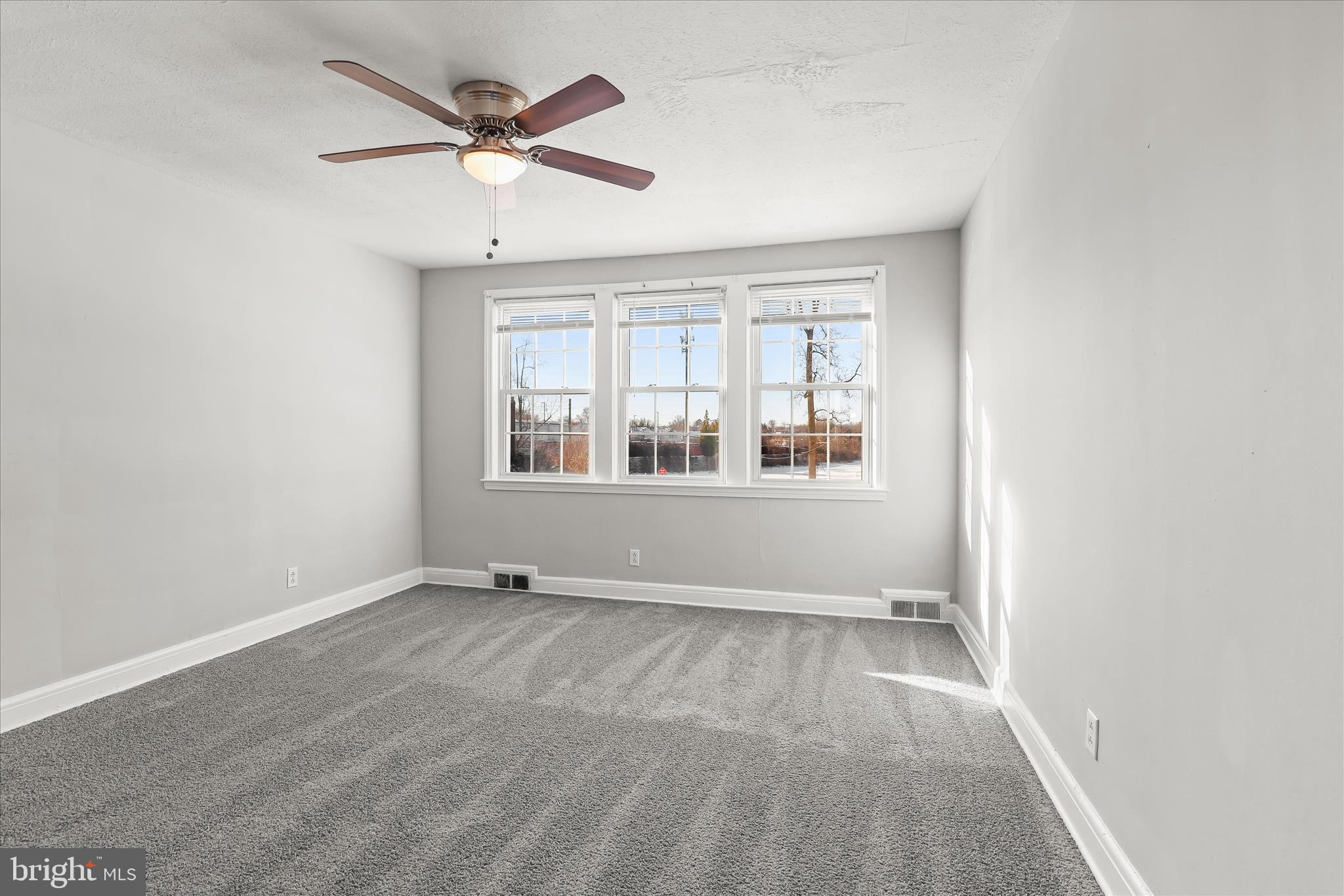 1945 Edgewood Road Towson, MD 21286 - Photo 21 of 46 an empty room with chandelier fan and windows