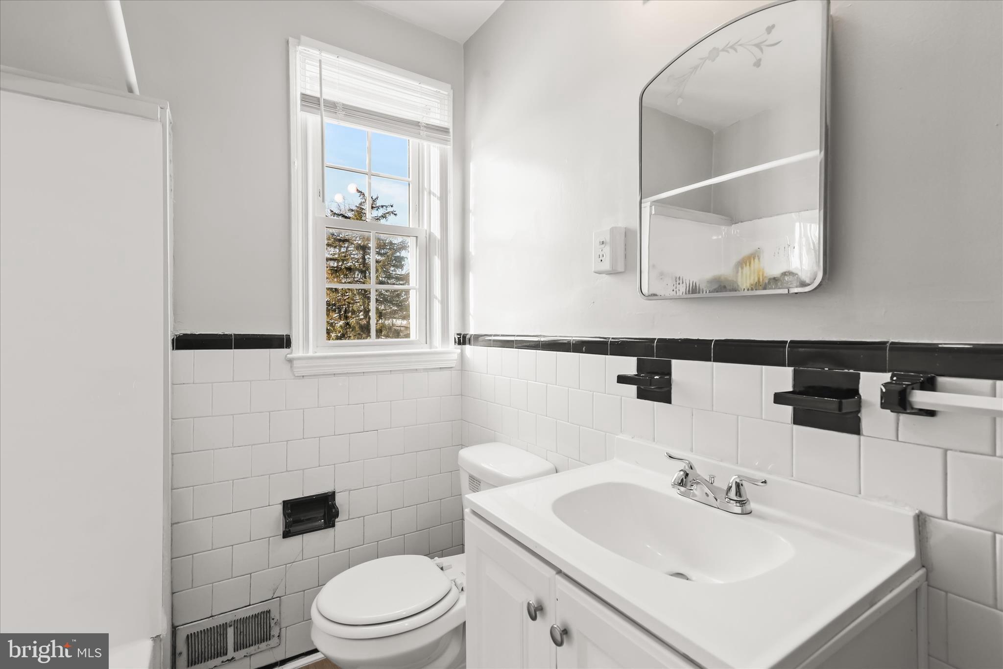 1945 Edgewood Road Towson, MD 21286 - Photo 27 of 46 a bathroom with a toilet a sink and mirror