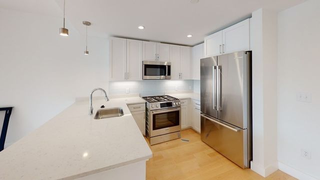 a kitchen with stainless steel appliances granite countertop a refrigerator sink and stove