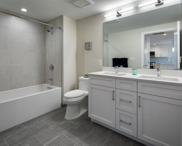 a bathroom with a toilet a sink a bathtub and a mirror