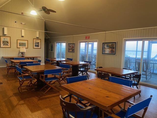 18 Canvasback Cove, Unit 122 Georgetown, SC 29440 - Photo 20 of 32 Dining space with lofted ceiling, ceiling fan, dark wood finished floors, and wooden walls