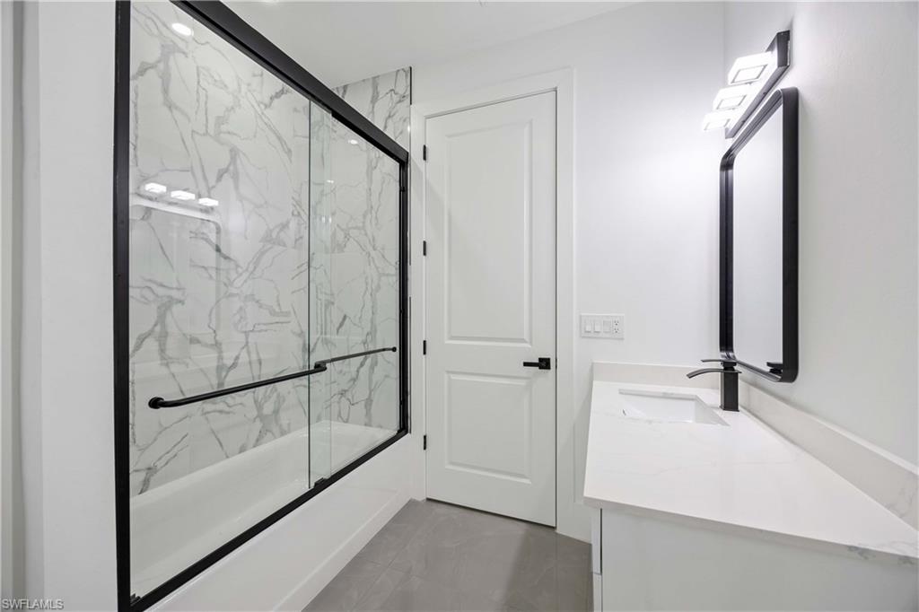 3908 Sunset Road Lehigh Acres, FL 33971 - Photo 22 of 30 a bathroom with a bathtub and a shower