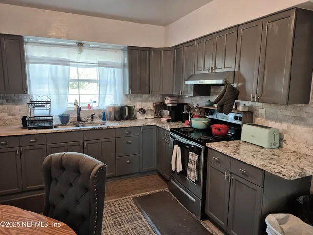 a kitchen with a sink a stove and cabinets
