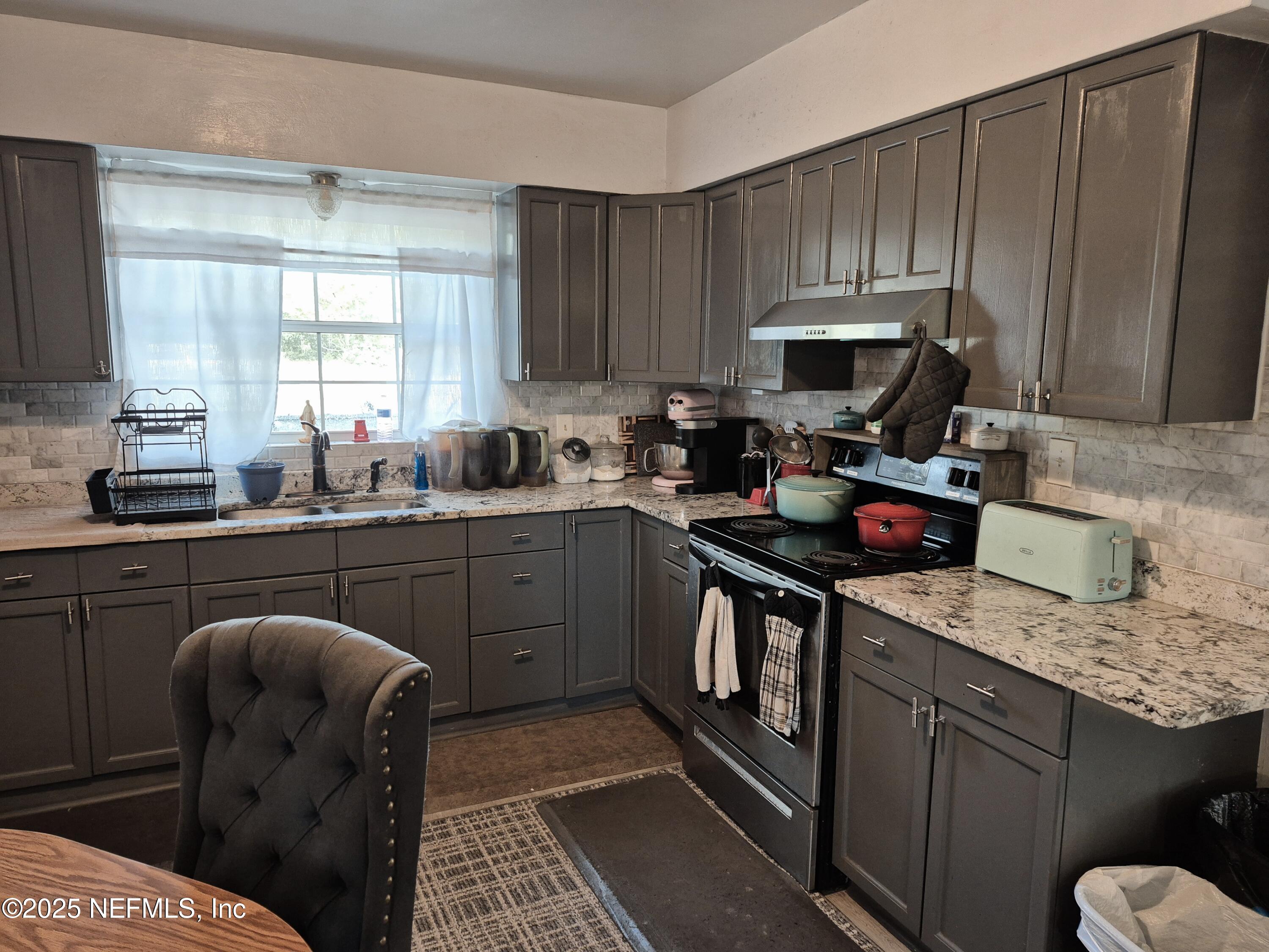 282 Byrd Road Crescent City, FL 32112 - Photo 11 of 24 a kitchen with a sink a stove and cabinets